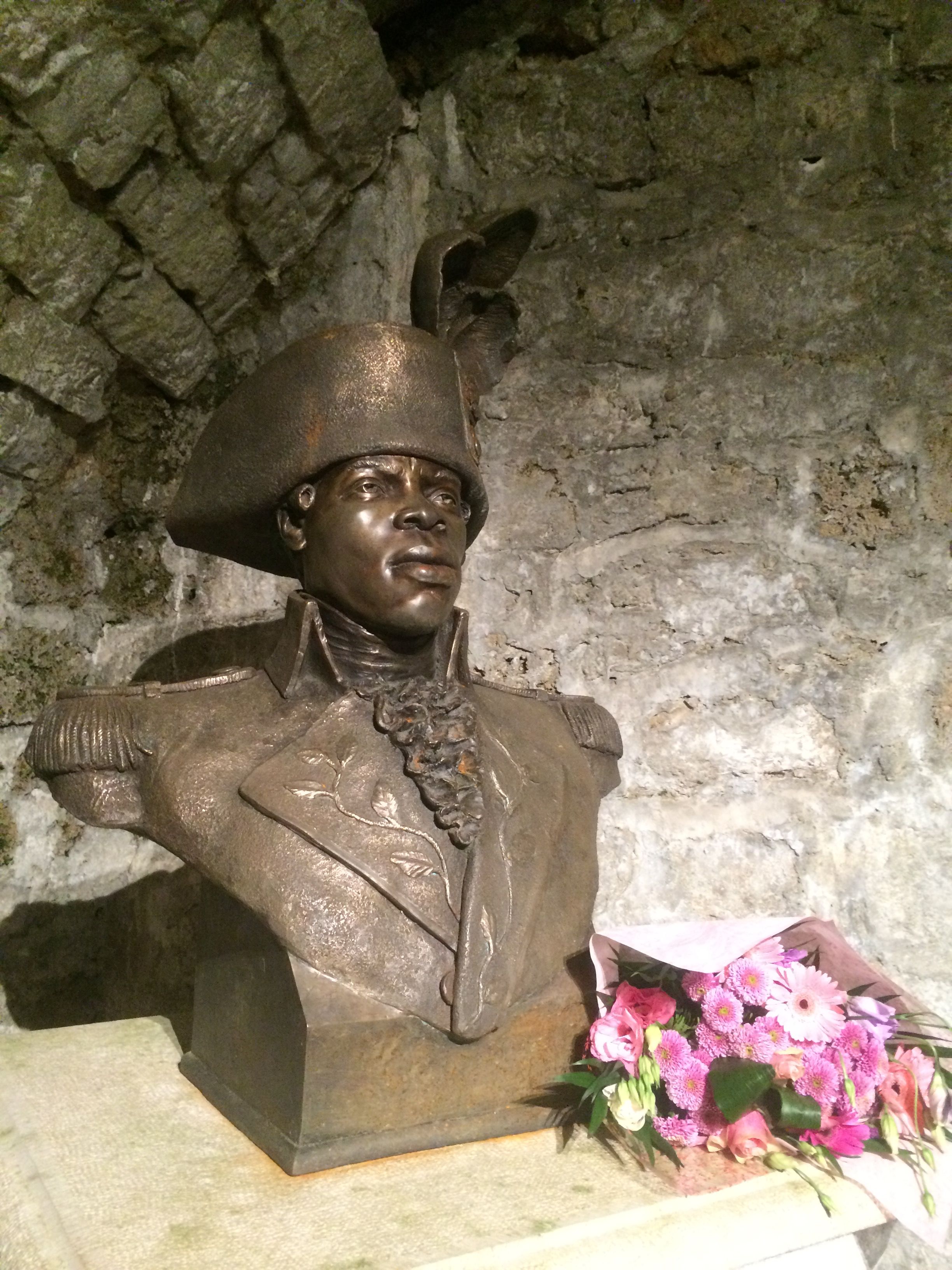 Dans la pièce voisine de la cellule de Toussaint Louverture au fort de Joux, le haut de son buste, fleuri. Chateau de Joux, 2016. (cc)Wikimedia/Chris93